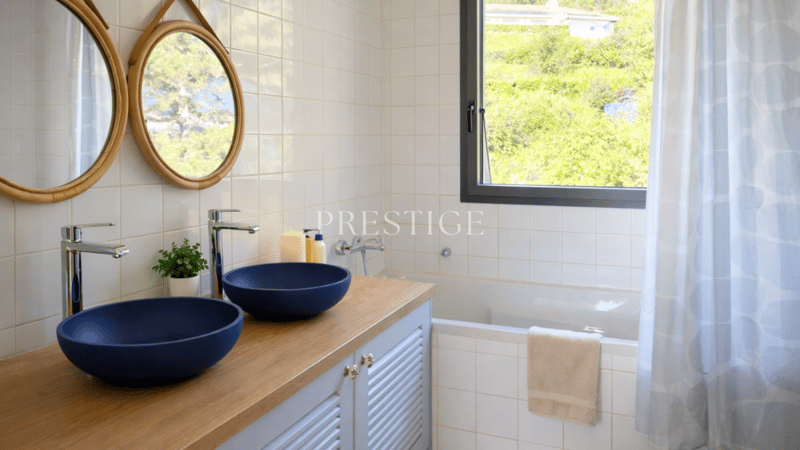 modern bathroom with double washbasin, bathtub, window to outside, tile flooring