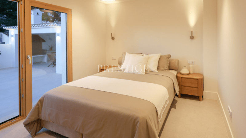 bedroom with a bed, nightstand, and a glass door leading to a balcony