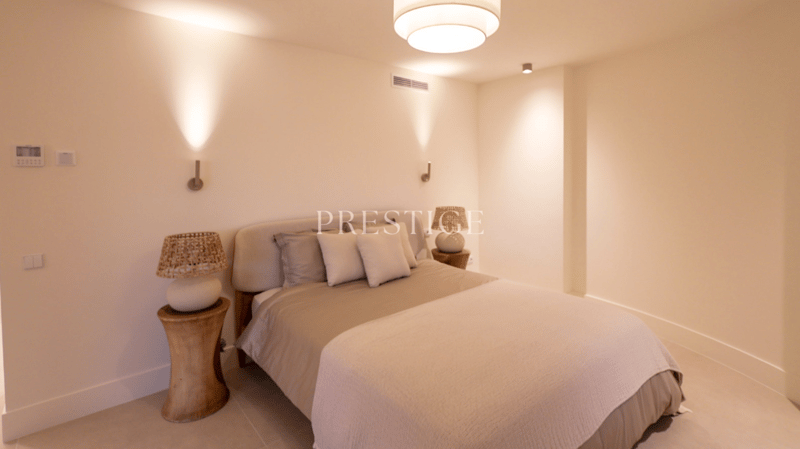 Bedroom with a bed, two nightstands, lamps, and a ceiling light.