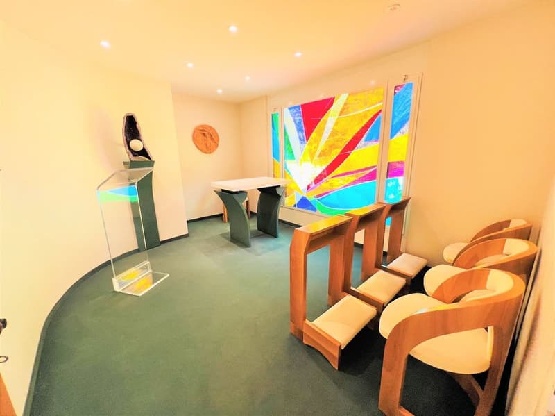 Colorful abstract artwork on the walls, modern furniture including chairs and tables, and a fireplace in the room.
