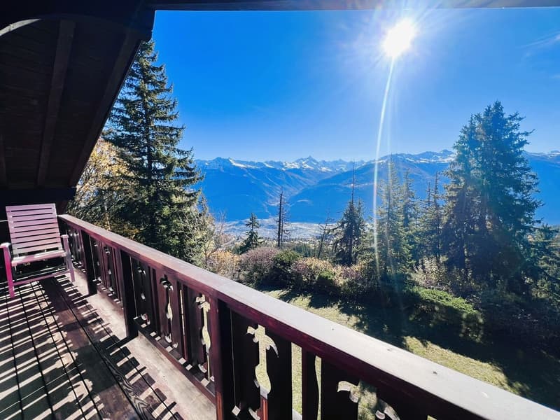 deck, wooden railing, sun, mountains in the background, trees