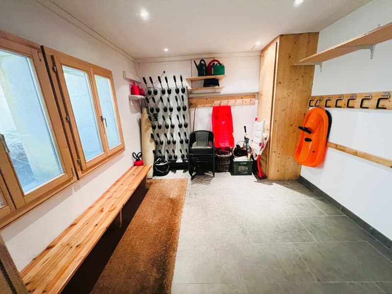 Storage room with wooden bench, shelves, and a red sled