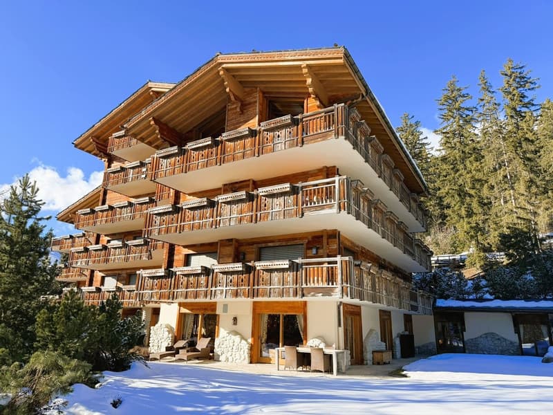 chalet style building, multiple balconies, snowy surroundings