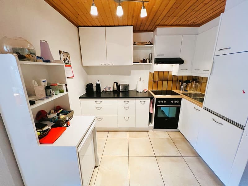 modern kitchen with white cabinets, black countertops, white appliances, tiled floor, wooden ceiling