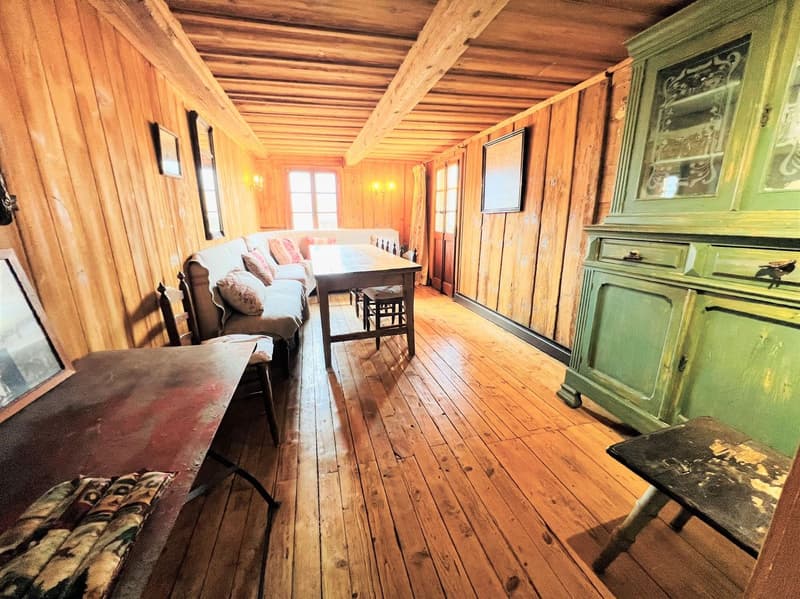 wooden walls, wooden floor, dining table, couch, wooden cabinet, picture frames