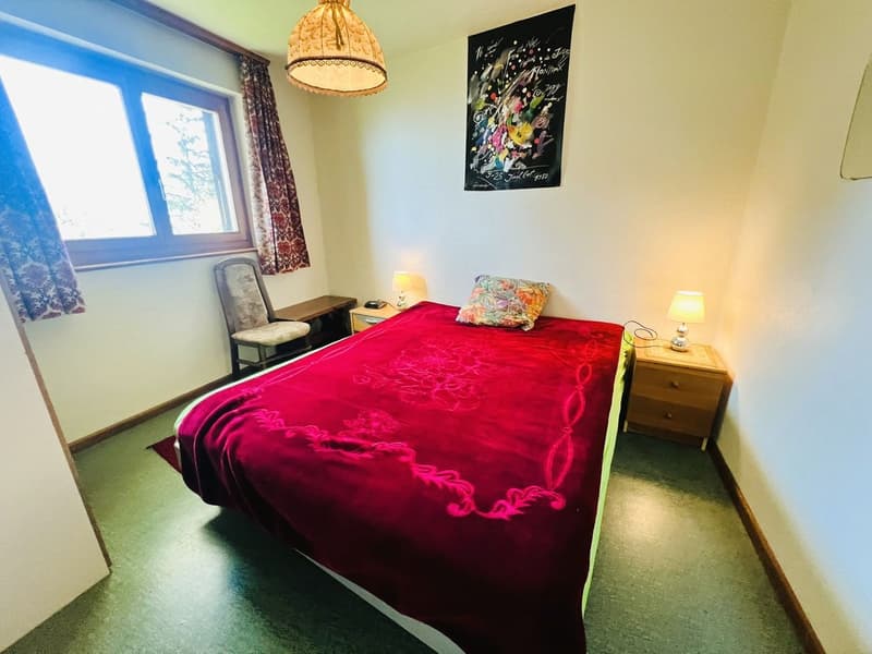 Bedroom with a bed, nightstands, lamp, chair, window, curtains, and a painting on the wall