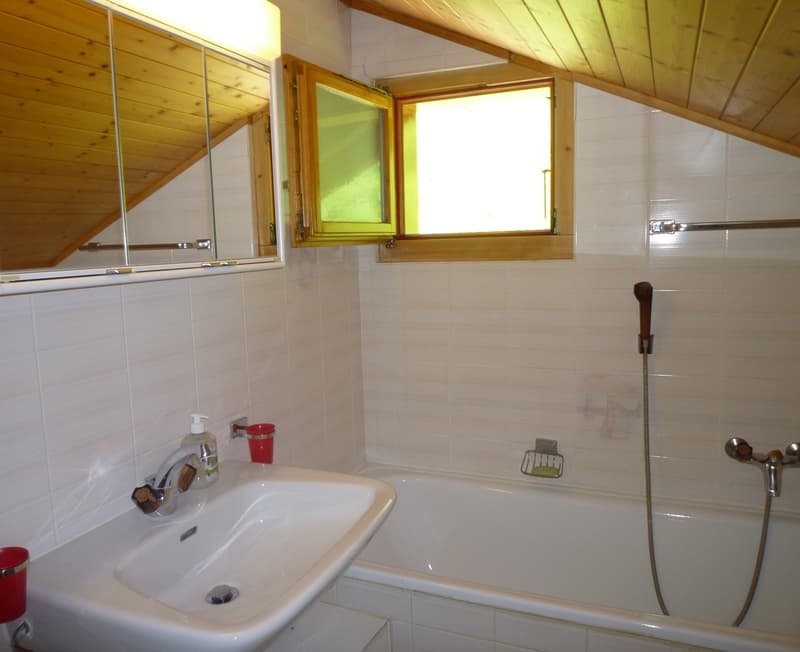 Bathroom with white tiles, wooden ceiling, sink, bathtub, and a window