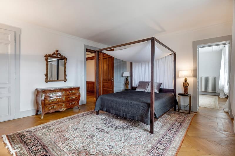Canopy bed, wooden floor, rug, nightstand, statue, lamp, mirror, wardrobe