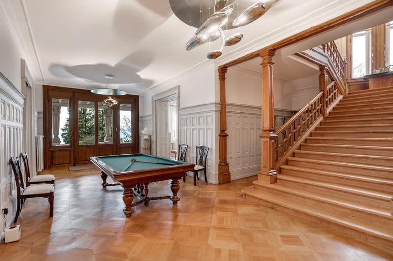 Wooden billiard table, wooden floor, wooden doors, windows with balcony view