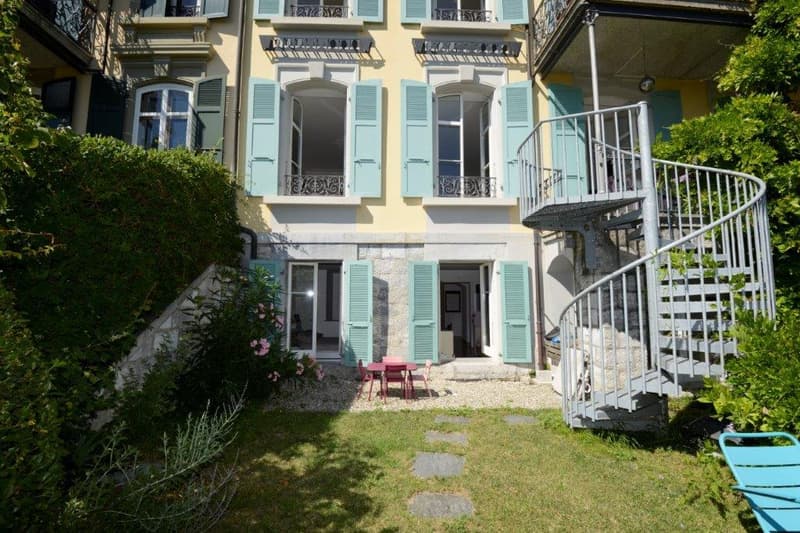 3 story house, yellow exterior, turquoise shutters, spiral staircase, outdoor dining area, patio furniture, garden