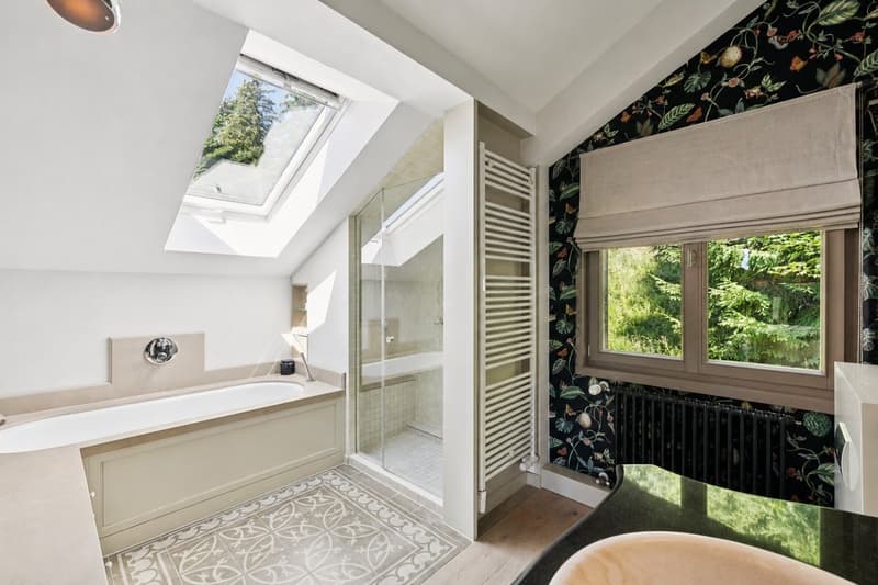 Grande salle de bains attenante à la suite parentale, équipée d'une baignoire et d'une douche pour un confort optimal.