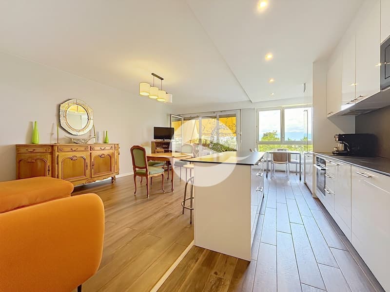 Cuisine entièrement équipée avec îlot central ouverte sur pièce de vie avec balcon orienté SUD avec toile solaire