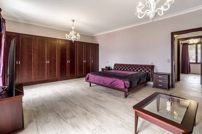 Chambre à coucher principale avec armoires murales et accès direct sur un balcon