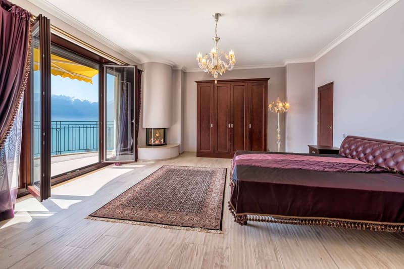 Grande chambre à coucher avec cheminée et accès sur un balcon