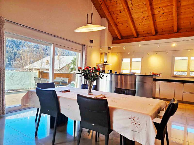 modern dining room, large windows, sliding glass doors, wooden ceiling, dining table, flowers in vase, kitchen