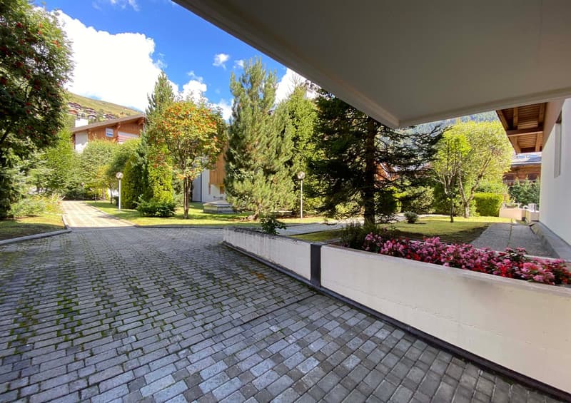 cobblestone driveway, flower bed, trees, shrubs, greenery, pathway, street light, building