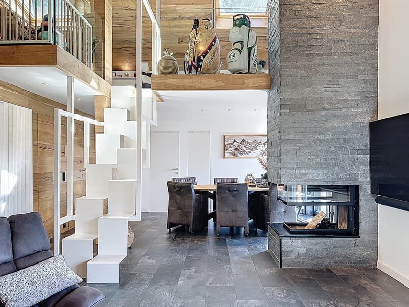 Wooden walls, stone flooring, cozy fireplace, modern dining area, staircase, living room