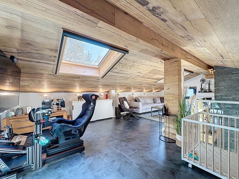 open space with wooden ceiling, gaming chair, sofa, crib, white couch, carpet, glass top table, skylight, indoor plant, wooden floor, wooden cabinet