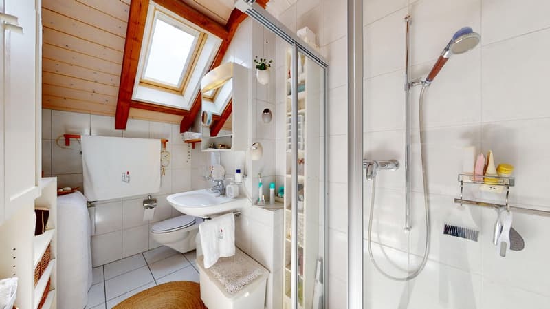 bathroom with a white sink, a white toilet, a shower, a window, shelves with personal care products