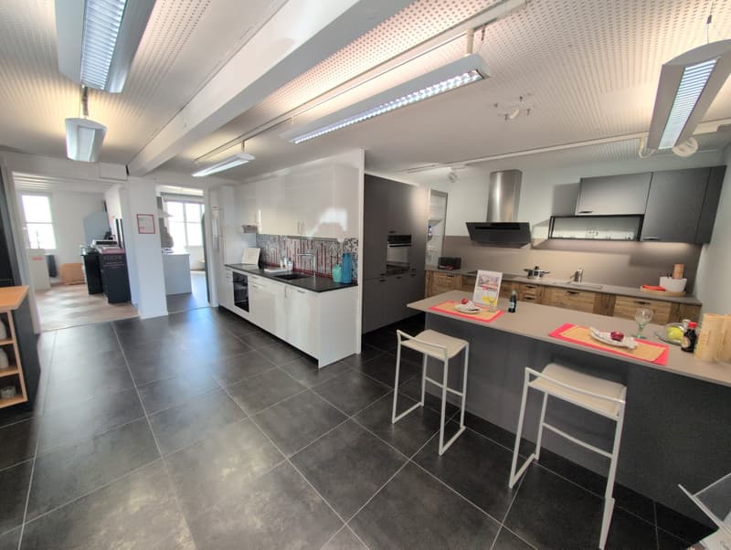 modern open-plan kitchen with integrated appliances and white cabinets, stainless steel appliances, large tiled floor, island with seating
