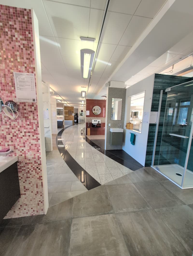 Empty bathroom with pink and white tiles, shower and sink, ceiling lights