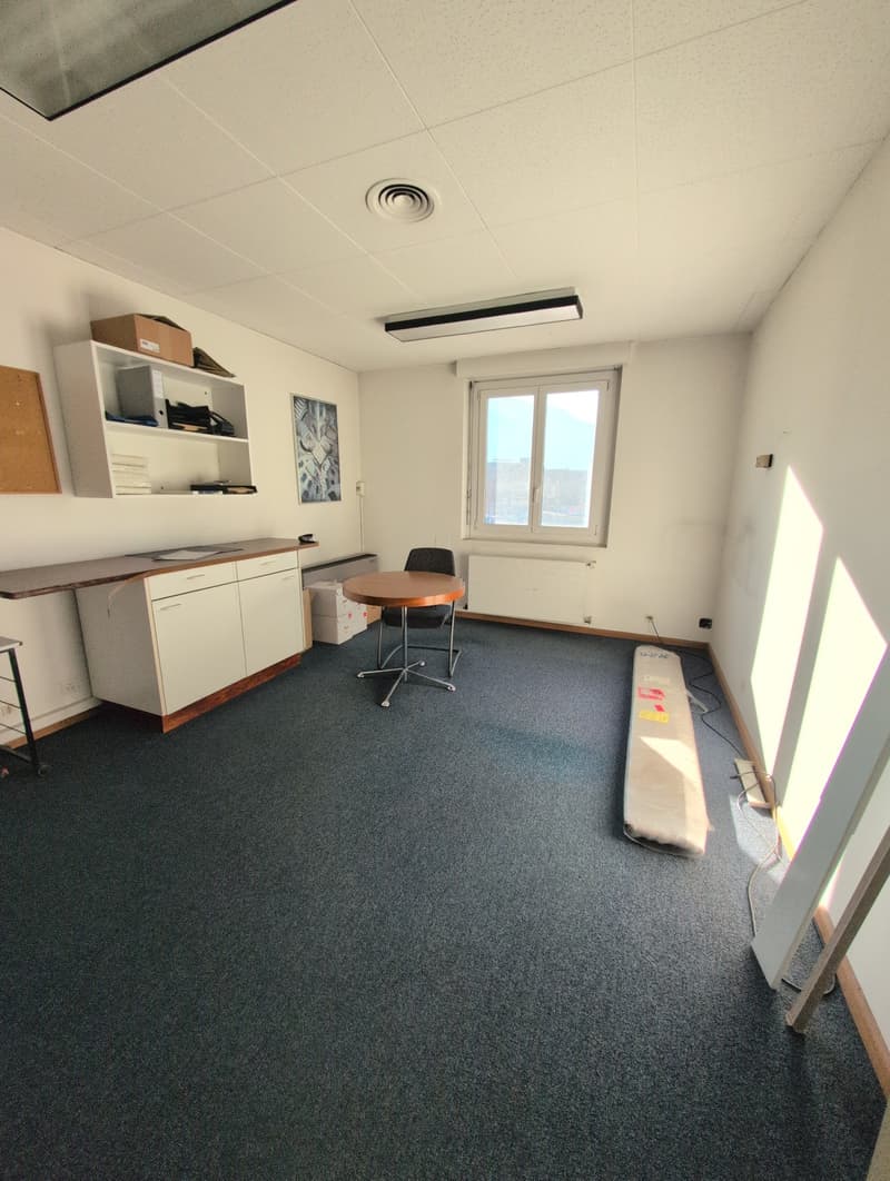 office room, white cabinets, desk, chair, shelves with books and boxes, window, carpet