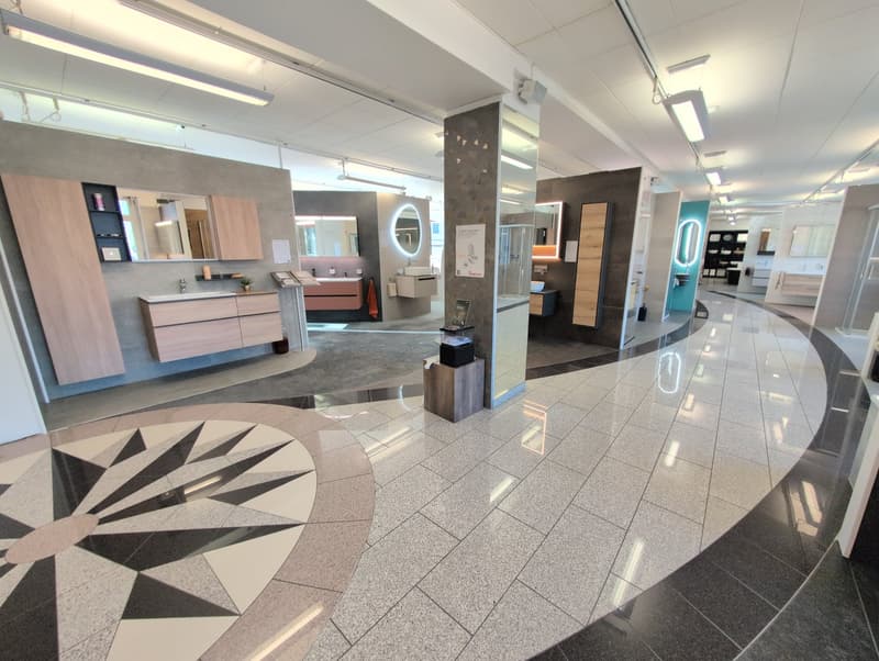 modern design, granite flooring, gray walls, wooden cabinets, glass mirrors, sinks, and toilets, central decorative element