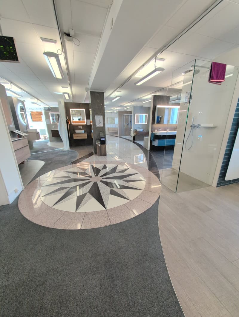 modern showroom, marble compass design floor, central heating radiator, various mirrors, glass shower room, white walls, white tiled floor, recessed ceiling lights