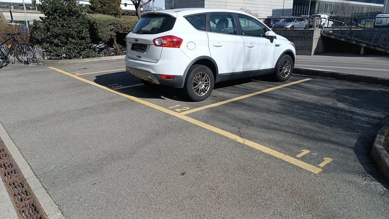 white car parked in the parking space with number 11