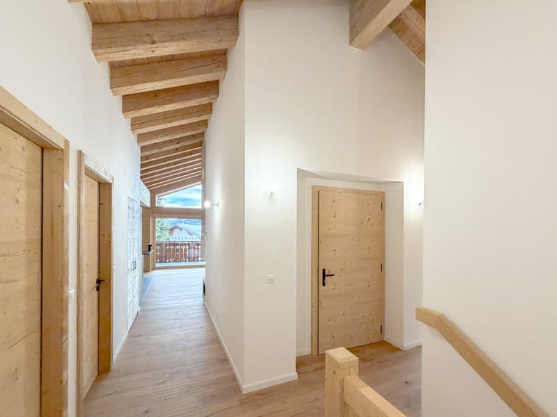 corridor with wooden doors, hardwood floors, wooden ceiling, white walls