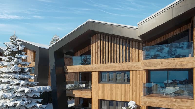 modern building with wooden facades, black accents, glass windows, balconies, snowy surroundings