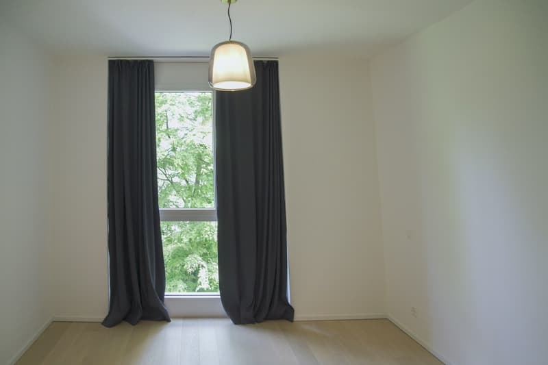 empty room, white walls, wooden floor, large window with curtains, pendant light
