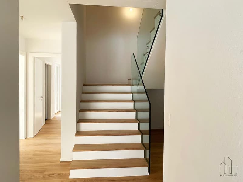Modern staircase with wooden steps and glass railings