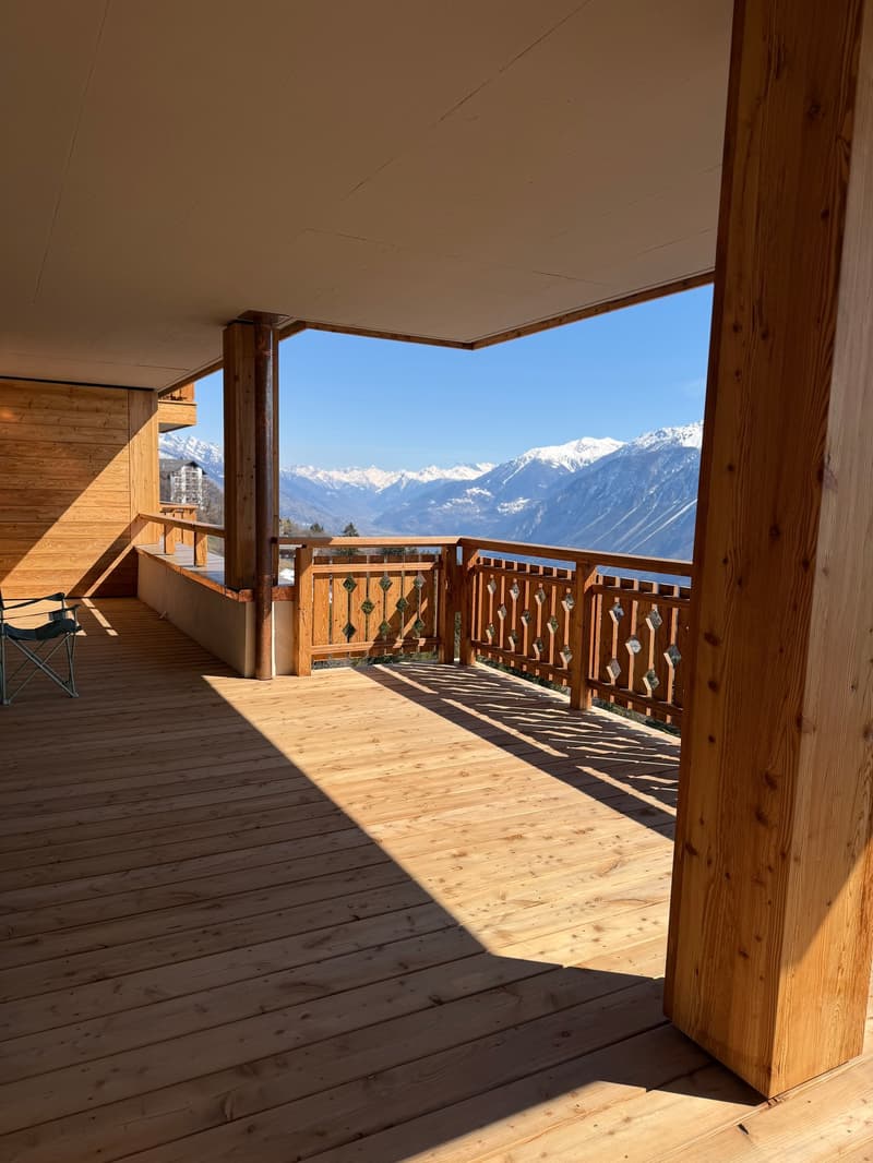 wooden deck, wooden railing, wooden columns, mountain view