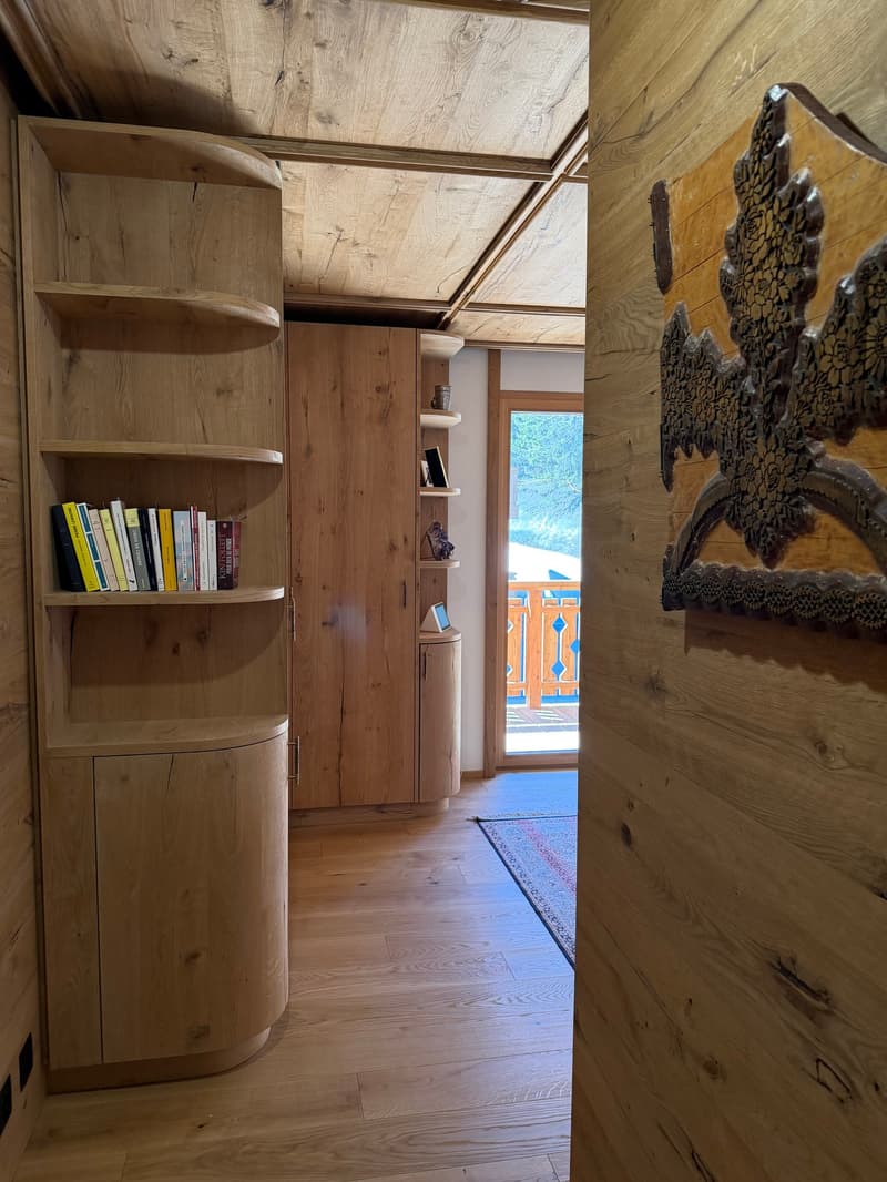 wooden floor, wooden walls, wooden shelves, books, rug, wooden cabinet, glass door, balcony