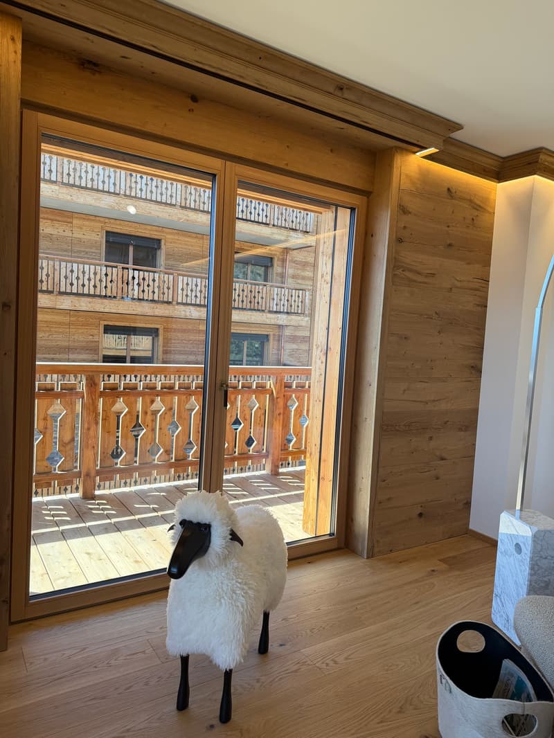 wooden floor, large glass door, balcony, wooden railing, sheep statue