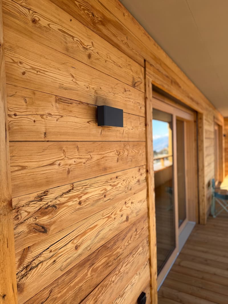 wooden wall, black outdoor light, glass door, wooden deck, balcony