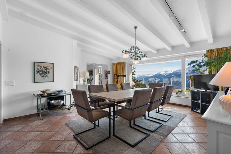 une grande pièce avec une table à manger et des chaises, avec une vue sur les montagnes depuis la cuisine et le salon / a large room with a dining table and chairs, with a view of the mountains from