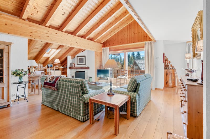 / a large open room with wooden ceilings and furniture