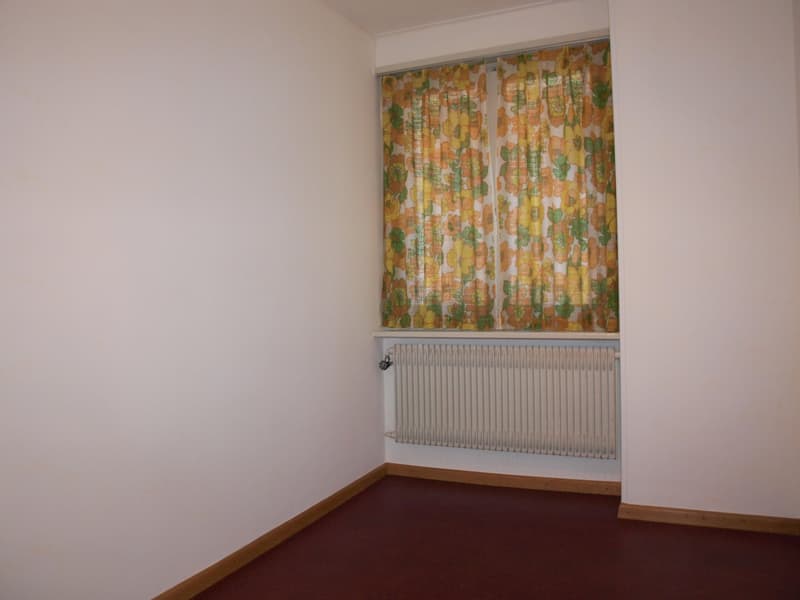 empty room, white walls, red floor, white radiator, floral curtains