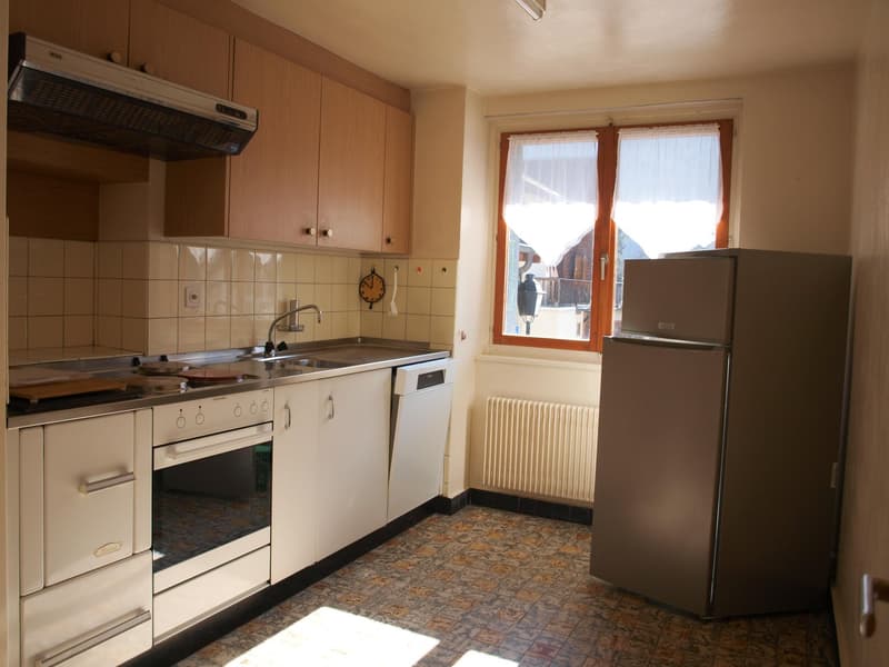 kitchen with white cabinets, tiled backsplash, stainless steel appliances, window with white curtains, radiator