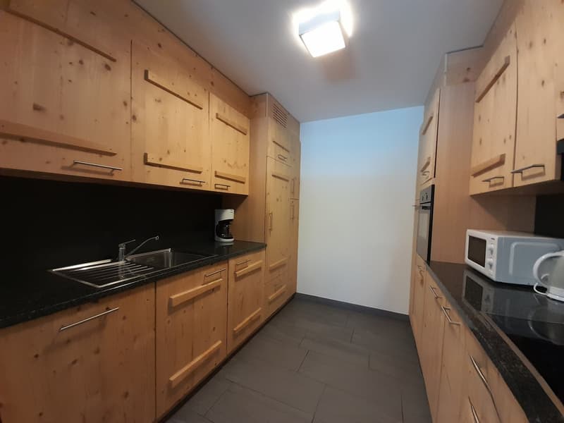 Kitchen with wooden cabinets, granite countertops, stainless steel sink, coffee maker, microwave, and kitchen appliances.