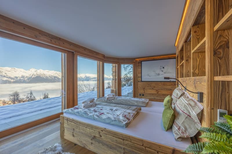 two beds, wooden headboard, TV, large windows, snowy mountains view, rug, wooden floor