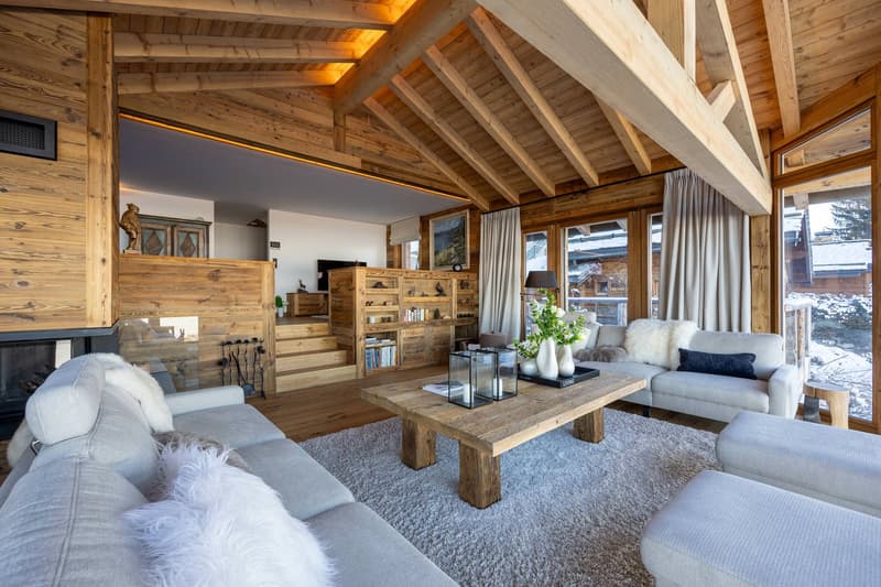 wooden walls, carpet, fireplace, glass windows, wooden stairs, table with vases, couches, lamps