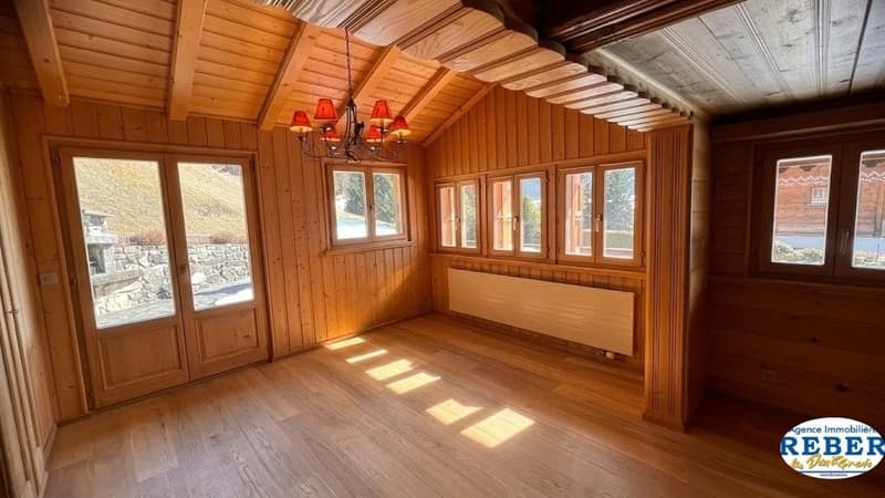 wooden walls, wooden floor, chandelier, radiator, double doors, windows