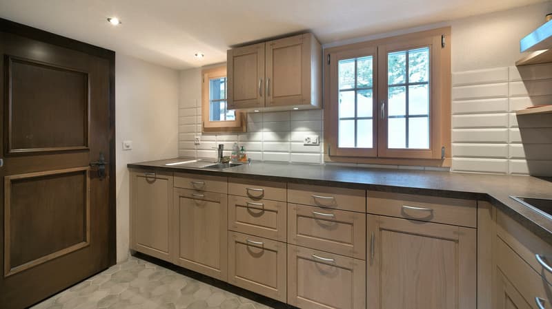 large kitchen with wooden cabinets, granite countertop, undermount sink, large window, double basin sink