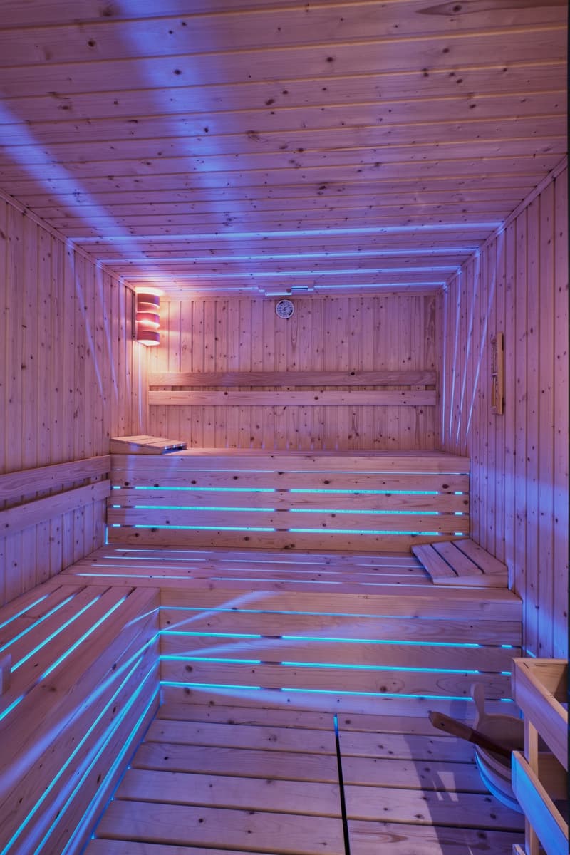 wooden walls, wooden benches, purple blue lighting, light on wall, clock on wall