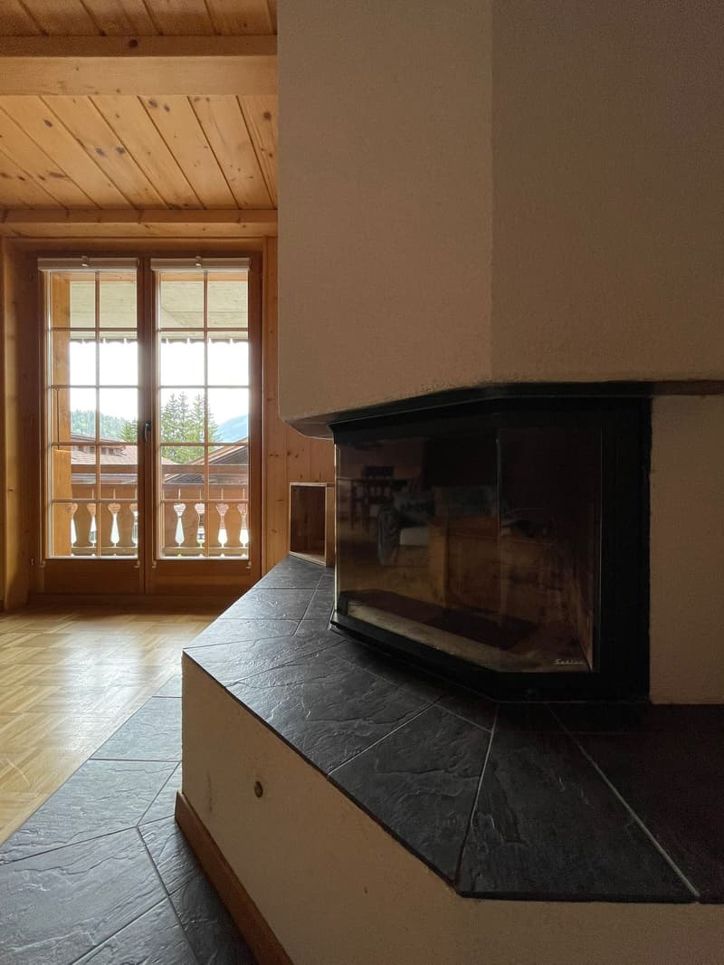 Wooden ceiling, large windows with balcony, stone fireplace, tiled floor