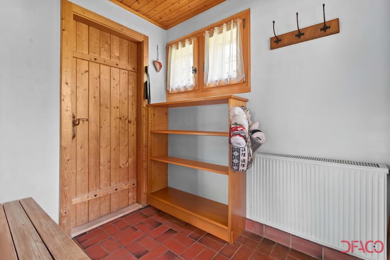 Wooden paneled walls, wooden shelves, tiled floor, radiator, wooden door, curtained window