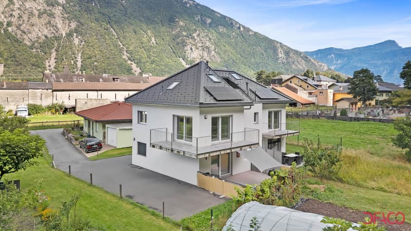 2 story house, white, raised ground floor, solar panels on roof, balcony, garden